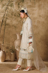 Woman in a traditional outfit standing against a textured wall with decorative vases.