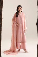 Woman in a pink traditional outfit standing between two trees on a white background