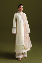 Woman wearing a cream and pink embroidered traditional outfit on a green background