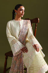 Woman in a traditional embroidered outfit sitting on a wooden chair against a green background