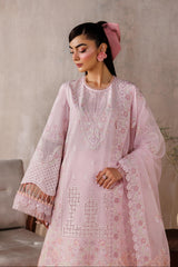 Woman wearing a light pink embroidered outfit with a neutral background