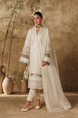 Woman in a traditional outfit standing against a textured wall with decorative vases.