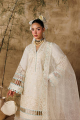 Woman in a traditional embroidered outfit with a neutral background