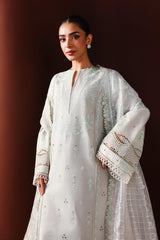 Woman wearing a white embroidered traditional outfit against a dark background
