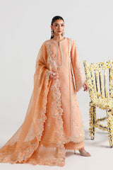 Woman in a peach embroidered traditional outfit with a white background